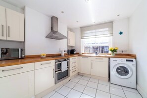Enjoy cooking in this well-equipped kitchen with an oven, microwave, and washing machine.