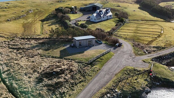 A coastal property with a main house, a smaller building, and a road leading to the sea. - The Wheelhouse (Isle of North Uist)