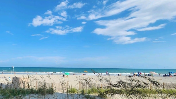 A beach with people, a clear sky, and the ocean. - Oceanfront Efficiency T108 (Myrtle Beach)