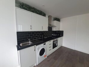 Enjoy cooking in this well-equipped kitchen with a stainless steel sink, microwave, oven, and washing machine.