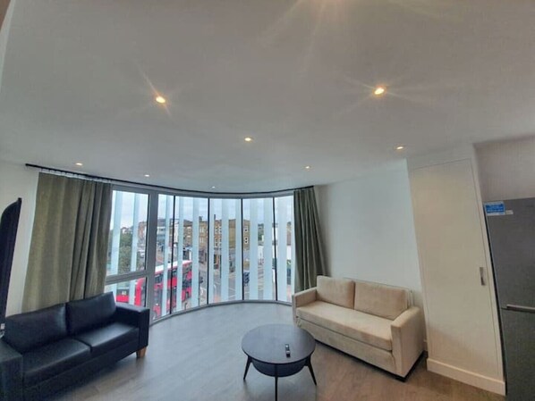 Enjoy a panoramic city view from the comfort of this stylish living room, featuring a sofa and small table for relaxing.