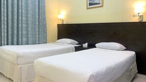 A hotel room with two single beds, a dark headboard, a nightstand, a lamp, and a framed picture on the wall. - Super OYO 152 Manam 1 Hotel Apartment (Muscat)