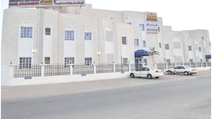 A building with multiple signs, including one for 'MANAM' and another for 'Al Arabiya'. - Super OYO 152 Manam 1 Hotel Apartment (Muscat)