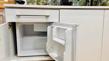 A kitchen with a white refrigerator, a white countertop, and a drawer.