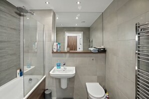 A modern bathroom with a glass-enclosed shower, a white sink, and a toilet. - Inviting 2-bed Apartment in Manchester (Manchester)
