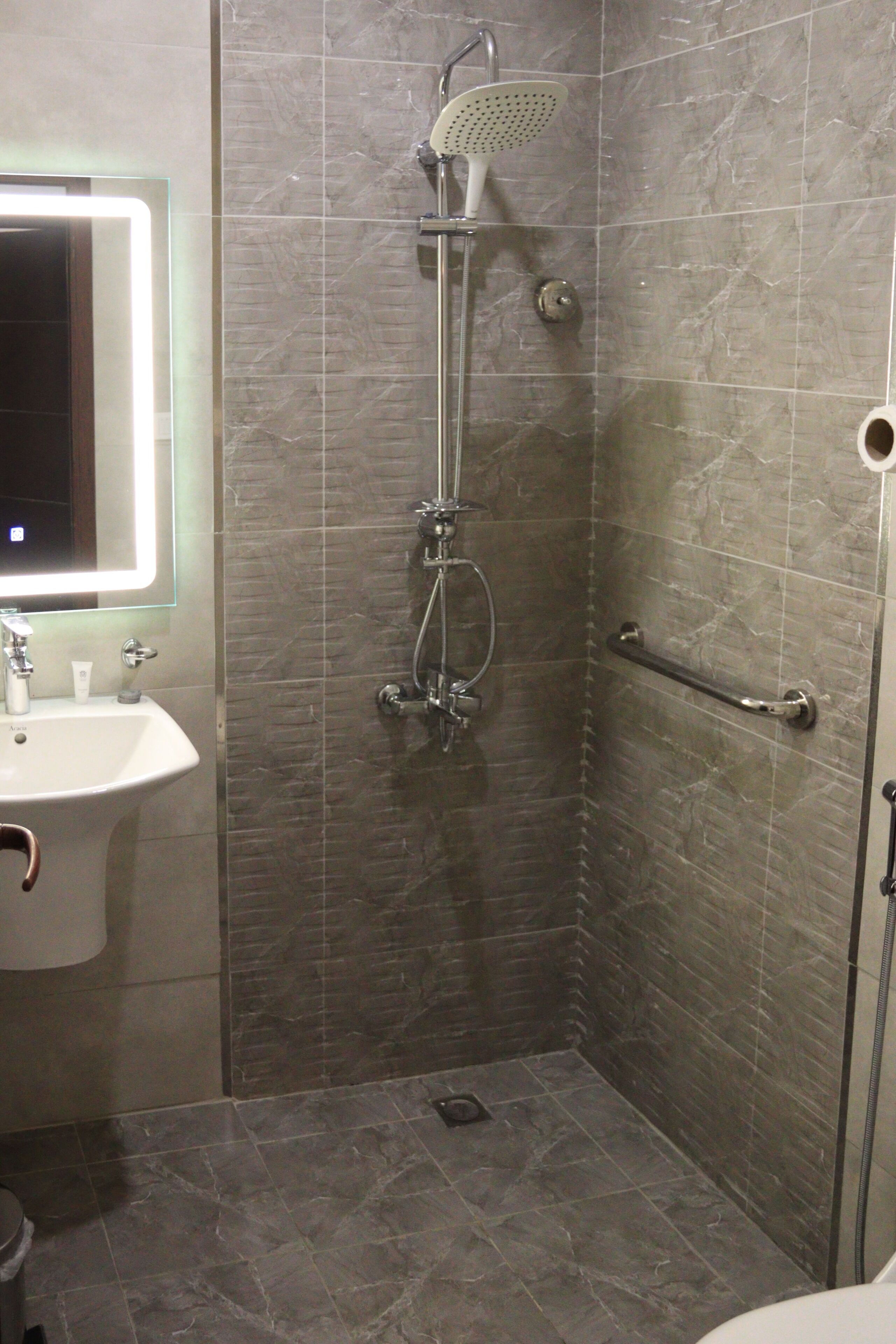 Un baño con ducha, lavamanos y espejo.