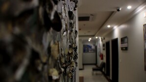 A hallway with a textured wall and a door at the end. - Swat Serviced Apartments 4 (Al Khobar)