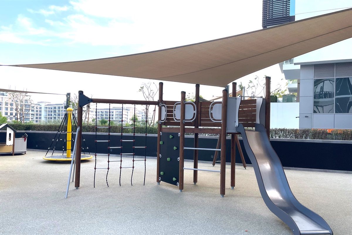 An outdoor playground with a slide, climbing structures, and a swing set.