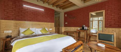 Una habitación con estructura de madera, una cama, una mesa y una silla.