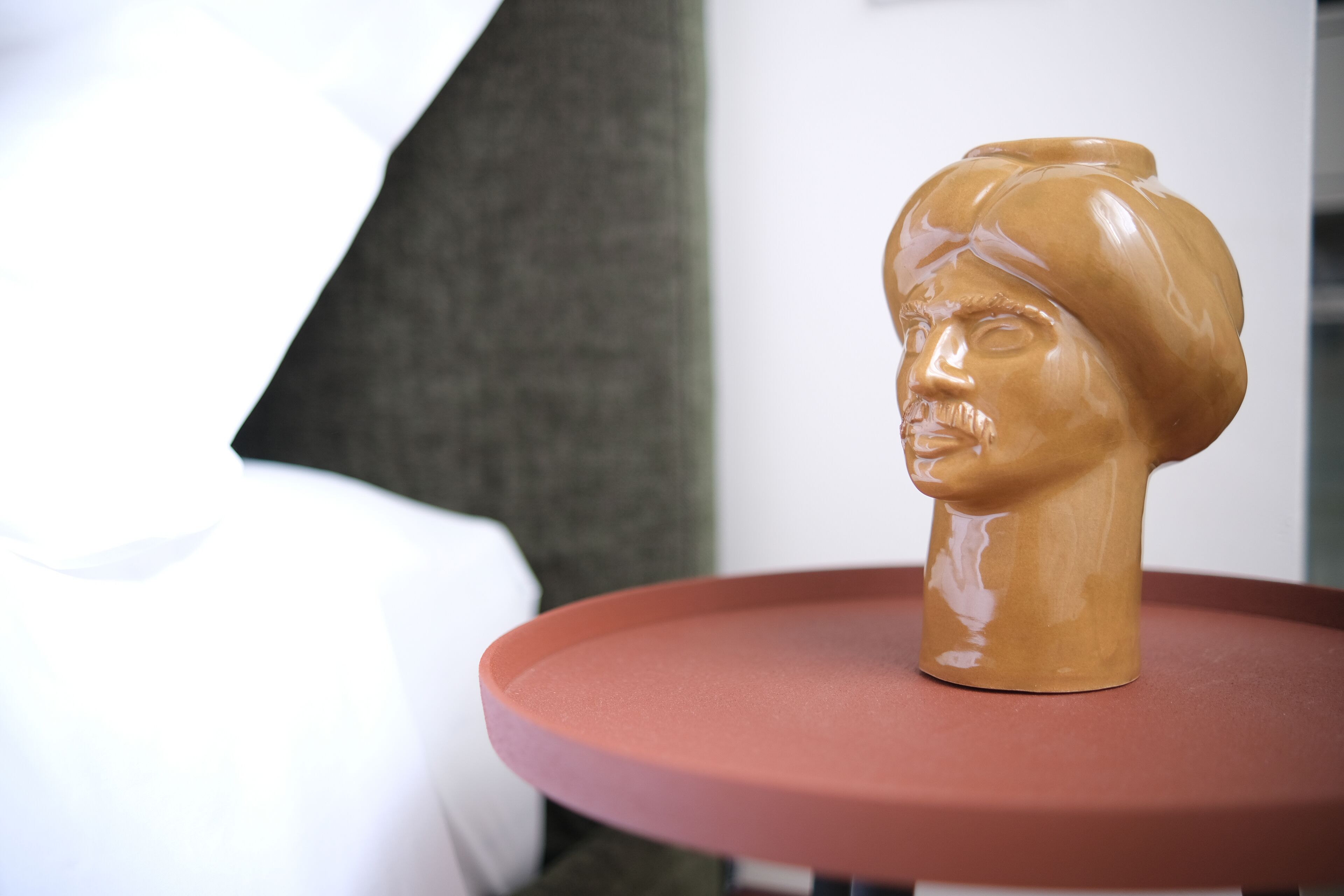 A bust sculpture on a red table.