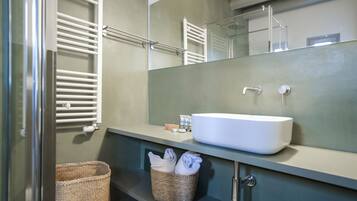 A bathroom with a white sink, a mirror, a towel rack, and a wicker basket.