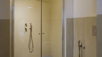 Une salle de bain moderne avec une douche à parois de verre, des toilettes blanches et un lavabo.