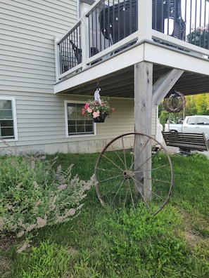 A house with a balcony, a hanging flower pot, and a large wheel.