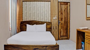 Une chambre à coucher avec un lit en bois, un bureau en bois et une porte dotée d’un trou de serrure.