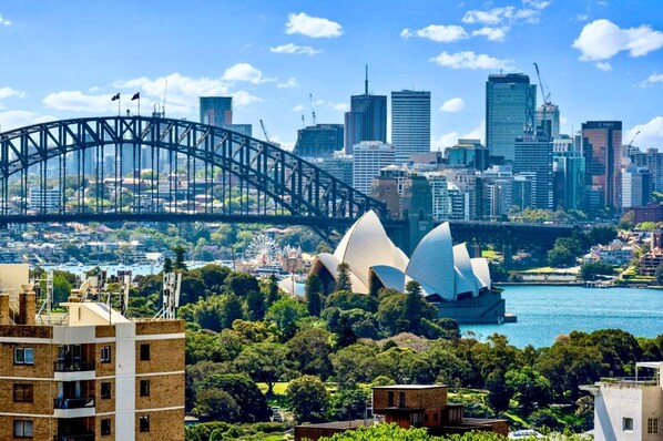 Experience the vibrant cityscape with stunning views of the iconic Sydney Opera House and a bustling urban skyline.