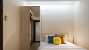 Un dormitorio con cama, armario y puerta que da a otra habitación.