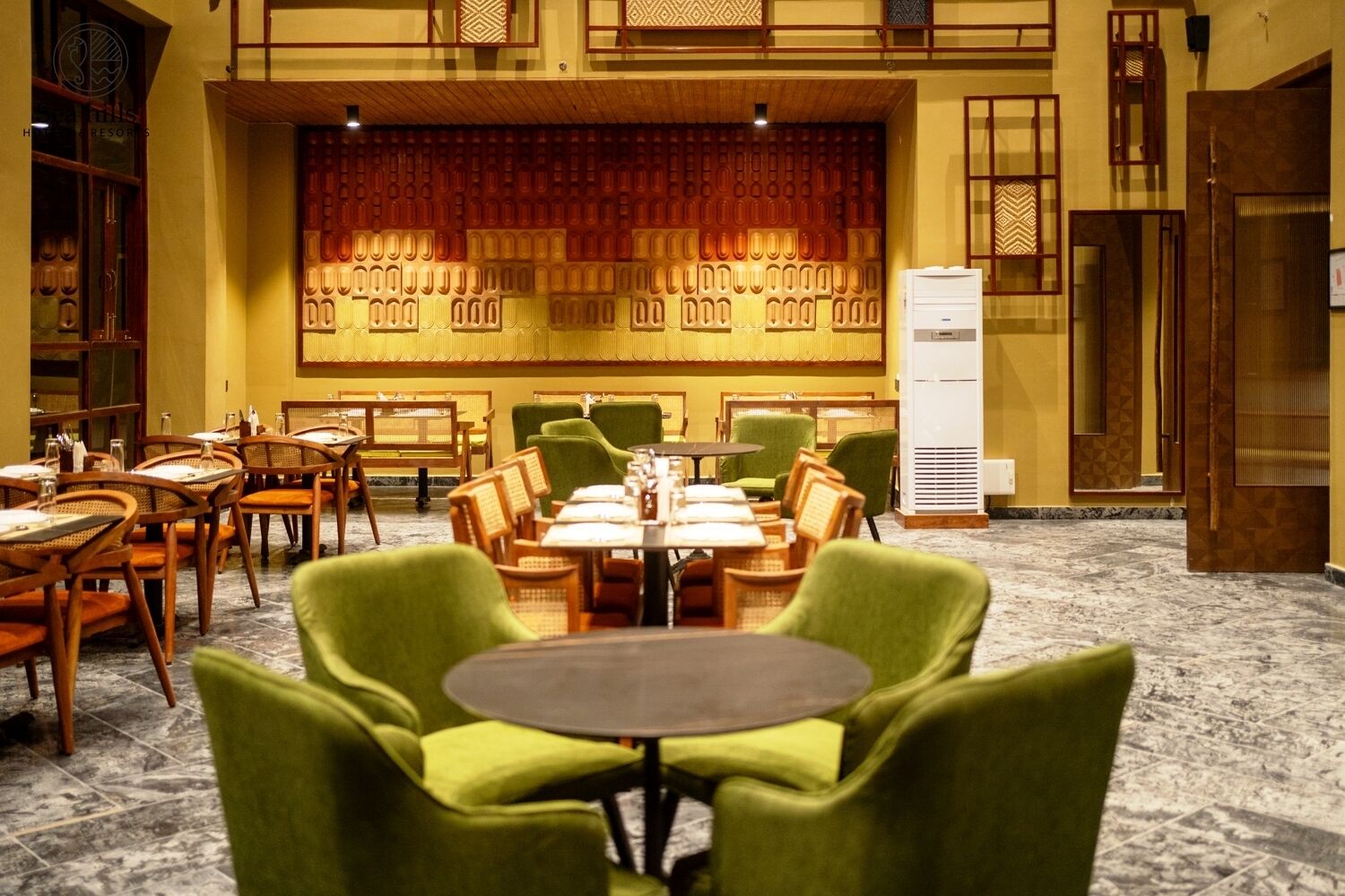 A hotel lobby with a traditional design, featuring wooden furniture and a patterned wall.