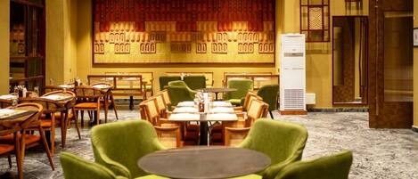 A hotel lobby with a traditional design, featuring wooden furniture and a patterned wall.