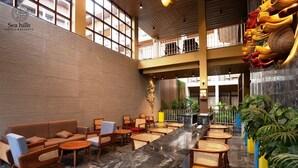 A spacious lobby with a high ceiling, a central bar area, and seating arrangements. - Sea Hills Resort Havelock (Port Blair)