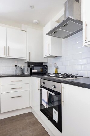 Enjoy cooking in this well-equipped kitchen with a stove, microwave, and kettle.