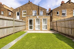 Traditional home with a well-maintained backyard and a brick exterior.
