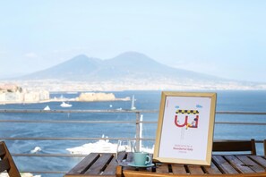 A framed welcome sign with a view of a coastal city and a mountain in the background.