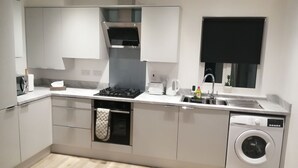 Una cocina moderna con lavavajillas incorporado, estufa y pileta.