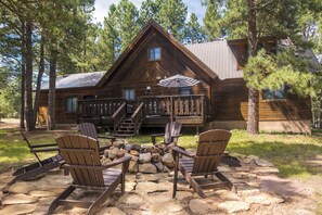 A wooden cabin with a deck, surrounded by trees. - Cozy Cabin w/Hot Tub, 2 King Suites, Firepit, Grill, Decks, Near Golf & Biking (Angel Fire)