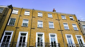 A yellow brick building with multiple windows and a red chimney. - Argo Hotel - Kings Cross (London)
