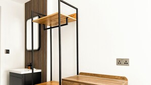 A modern bathroom with a wooden vanity, a mirror, and a black metal frame. - Argo Hotel - Kings Cross (London)