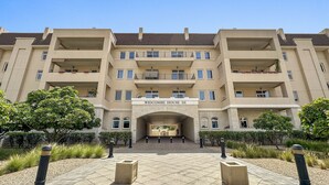 A multi-story building labeled "Widcombe House III" with a central entrance, balconies, and a landscaped courtyard. - Elegant Apartment Retreat at Widcombe House 3 (Dubai)