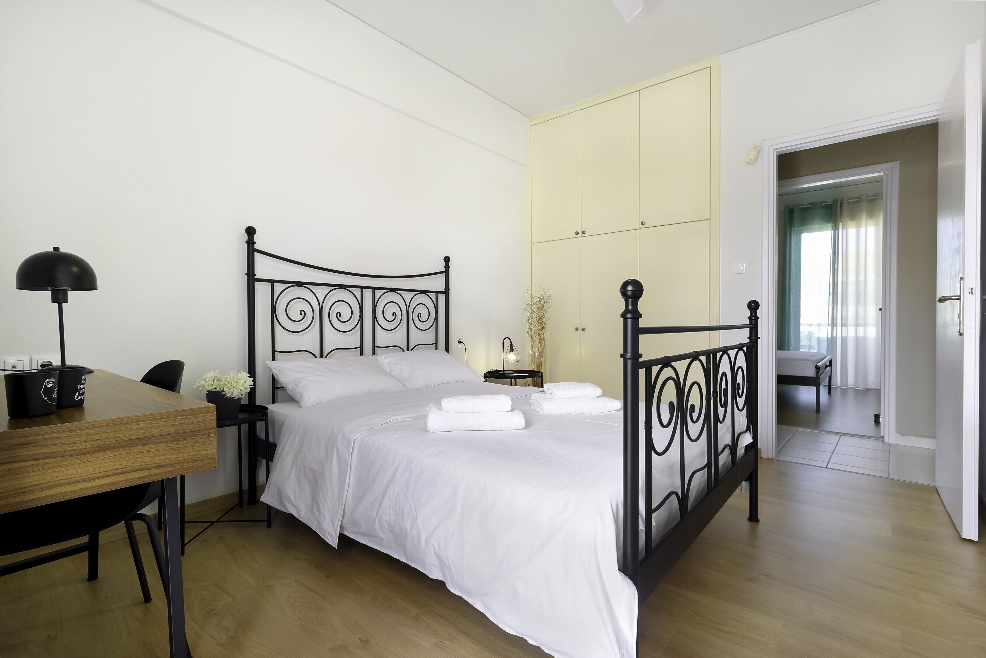 Una camera da letto con un letto, un comodino, una lampada e una scrivania.