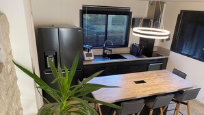 A modern kitchen with a built-in refrigerator, a sink, and a dining area with a table and chairs.