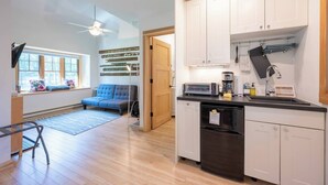 A compact kitchen with white cabinets, a built-in oven, and a coffee maker. - Walkable Ephraim Duplex | Fall Days & Cozy Nights (Ephraim)