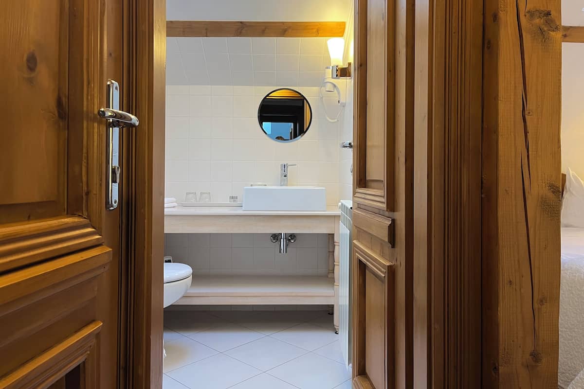 Un baño con lavamanos, espejo y retrete.