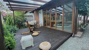 A wooden deck with a hammock, ottoman, and woven pouf. - Tohanu Vechi (Zarnesti)