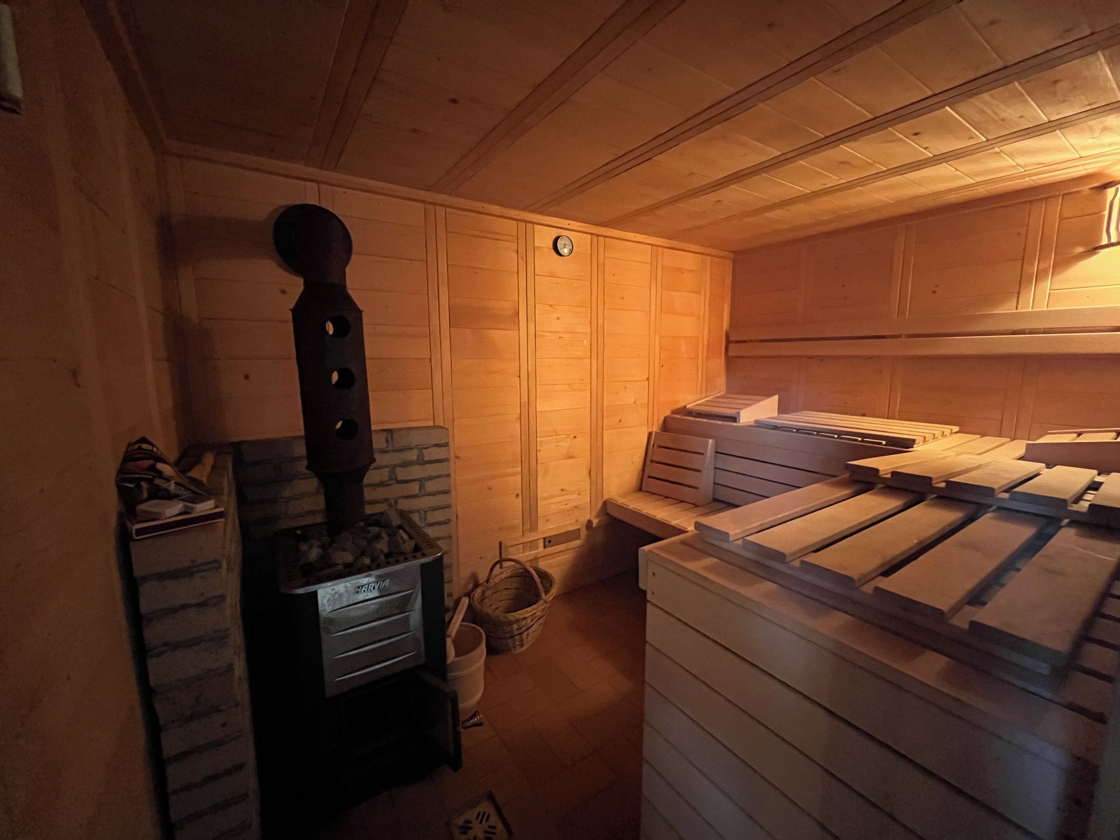 Una sala de sauna con sauna, bancos y una pared de madera.