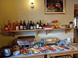 Una mesa de buffet con diferentes alimentos y botellas de vino.