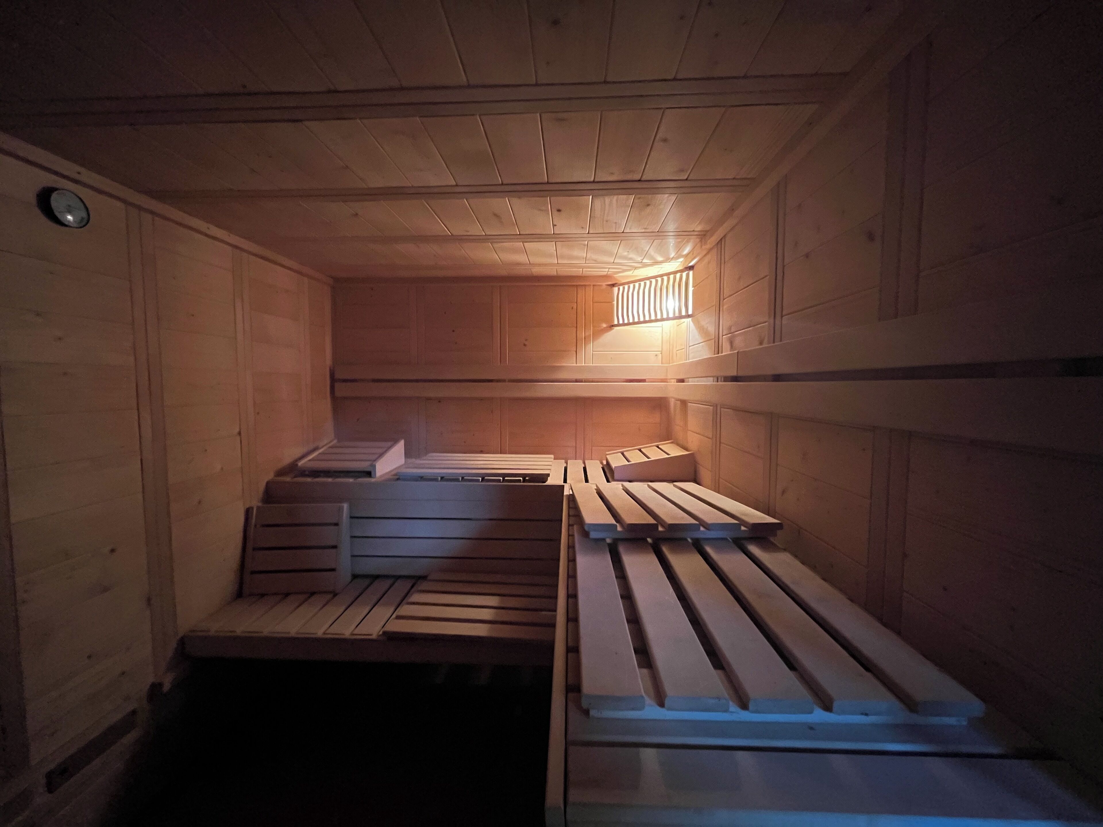 A sauna with wooden benches and a slanted ceiling.