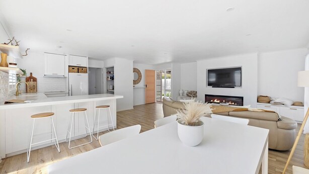 A modern living space with a kitchen, dining area, and a fireplace. - Castaway, Cowes beach house (Cowes)