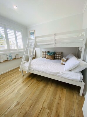 A bunk bed with white bedding and pillows, a ladder, and a framed picture on the wall. - Castaway, Cowes beach house (Cowes)