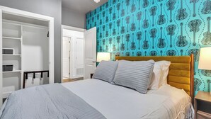 A bedroom with a bed, a wardrobe, and a wall with a guitar pattern. - Walk to Gruene-Guadalupe Riverfront-River Access-Stylish Texas Music Retreat (New Braunfels)