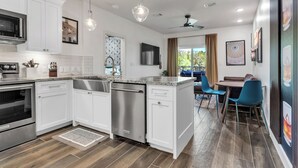 A modern kitchen with white cabinets, stainless steel appliances, and pendant lighting. - Walk to Gruene-Guadalupe Riverfront-River Access-Stylish Texas Music Retreat (New Braunfels)