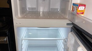 An empty refrigerator with two shelves and a freezer compartment.