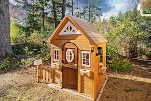 Eine kleine Holzhütte mit Satteldach, einer Eingangstür und zwei Fenstern.