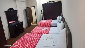 Ein Hotelzimmer mit zwei Betten, einem Kleiderschrank und einem Spiegel.