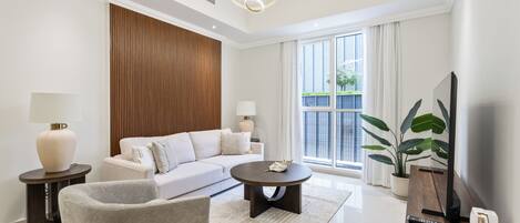 Deluxe Apartment | Living area | 65-inch Smart TV with cable channels