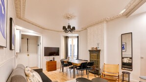 Un salón amplio con comedor, televisión y chimenea.
