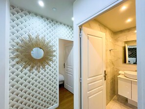 A bathroom with a mirror, sink, and toilet. - UrbanFlat 17 - Pretty 3 Bedroom Flat in Paris Center (París)