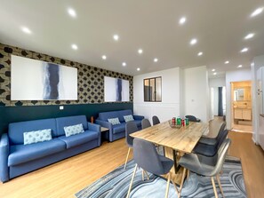 A modern living room with a sofa set, a dining table, and a kitchen area. - UrbanFlat 17 - Pretty 3 Bedroom Flat in Paris Center (París)